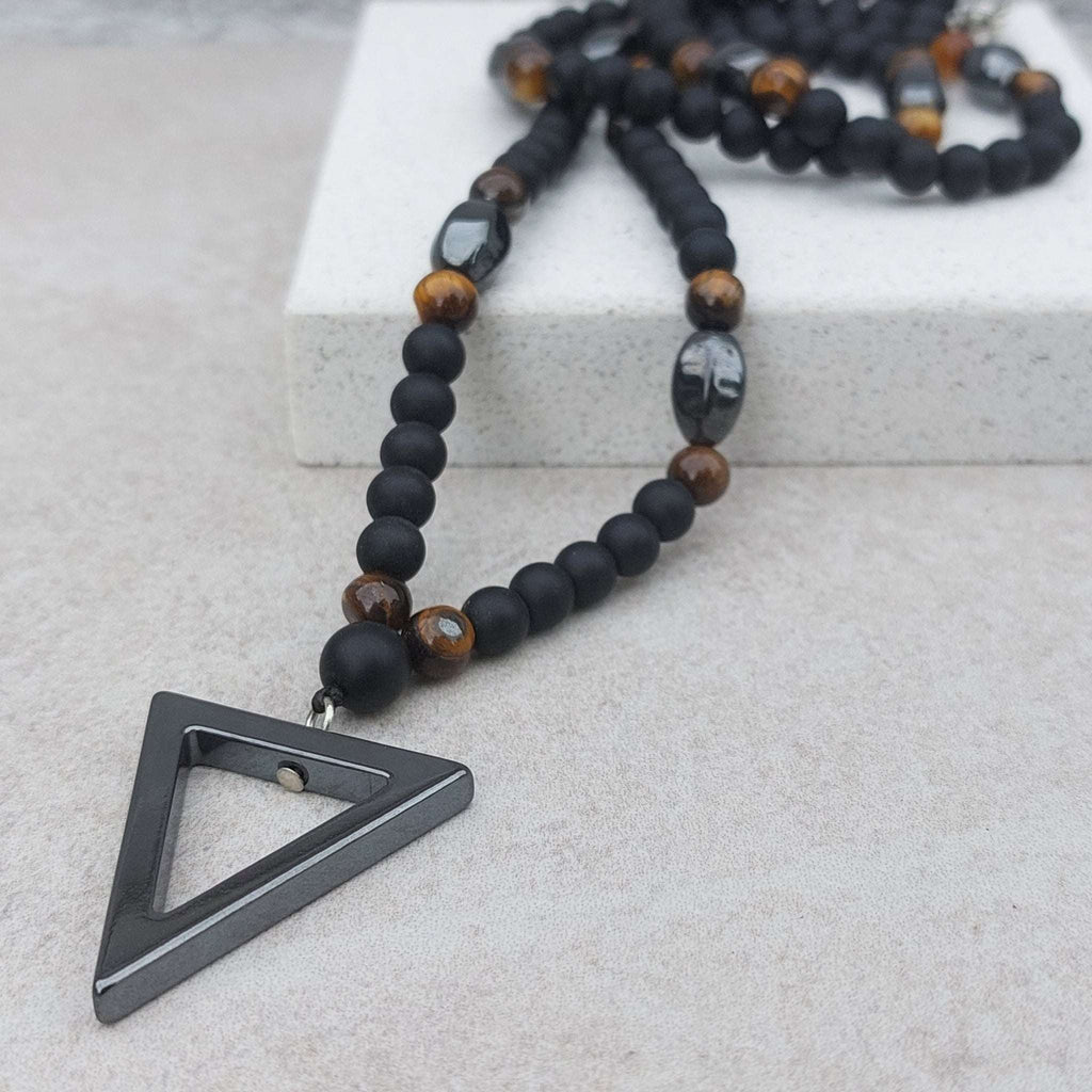 Andino Beaded Triangle Necklace with hematite, tiger eye, and black onyx beads, featuring a modern triangle pendant.